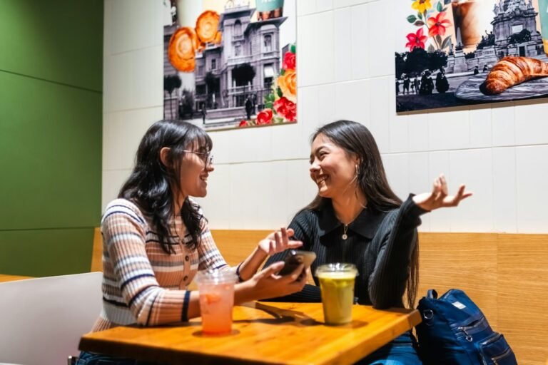 Adult friends talking in a cafe, illustrating the friendship recession and adult friendship