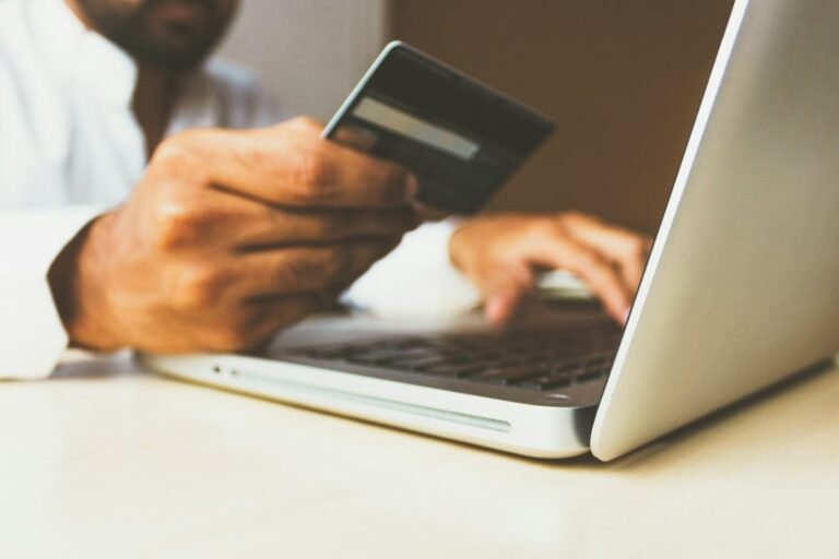 Online shopping on a laptop with a credit card, illustrating agentic commerce and AI shopping agents