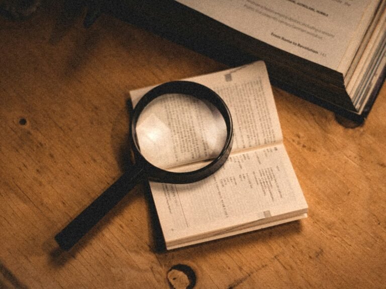 Magnifying glass on an open book representing evidence evaluation and epistemic trust